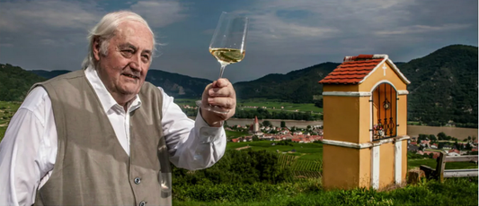 Photo of Father Hans Denk holding a Zalto wine glass, which he designed.